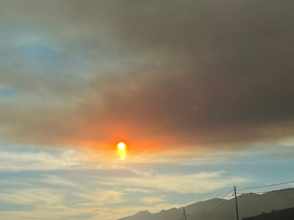 a burnt orange sun on the 101 near Santa Barbara covered by smoke from a nearby fire. It is setting into the blue skies which remind me of the pacific ocean.
