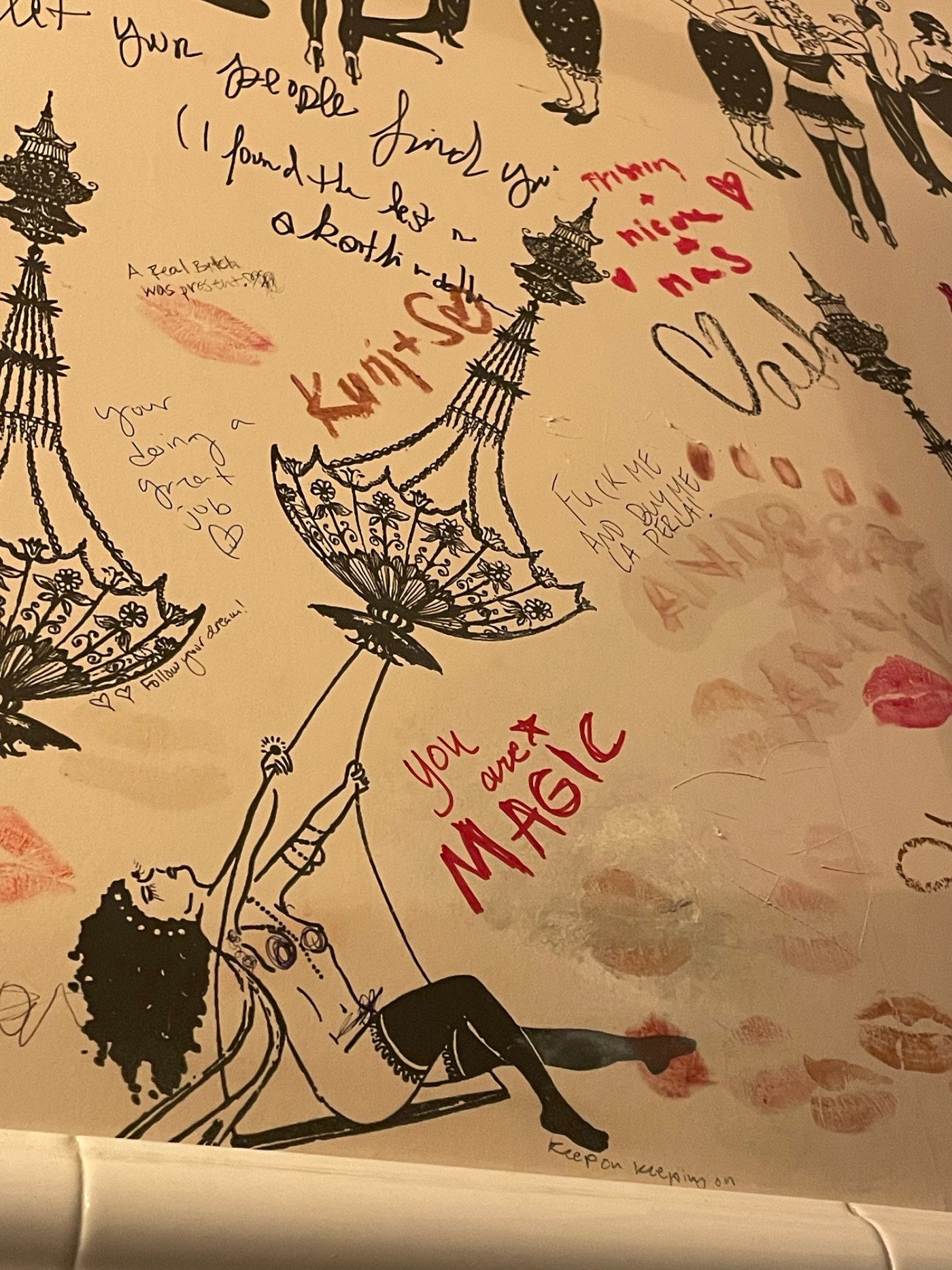 bar bathroom art. Featuring a drawing of a woman swinging from a chandelier with the writing You are magic.